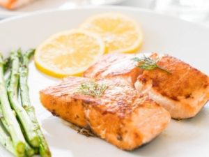 salmon on a plate with asparagus and lemon